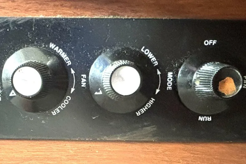 Slide: The Image of Control panel with knobs for fan, temperature, and mode on a 1987 Davidson 48 Sportfish. - 49