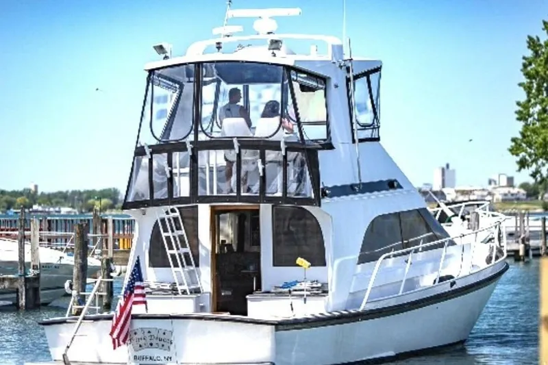 Slide: The Image of 1987 Davidson 48 Sportfish yacht docked at marina, featuring spacious upper deck. - 6