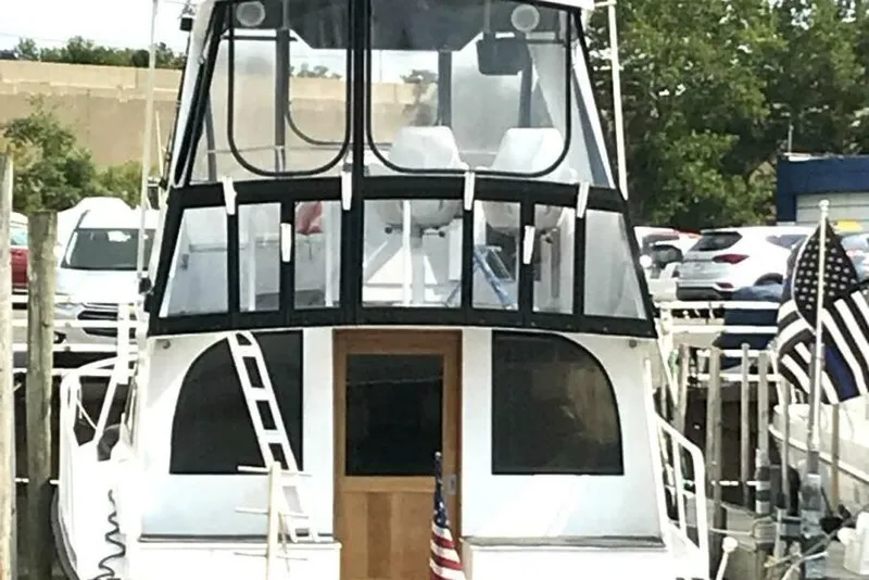 Slide: The Image of 1987 Davidson 48 Sportfish boat docked, featuring a sleek design and American flag. - 7