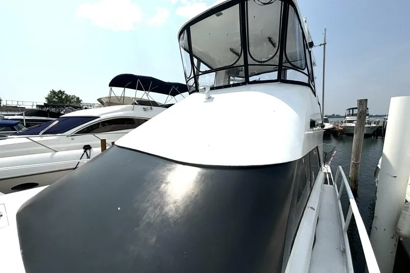 Slide: The Image of 1987 Davidson 48 Sportfish yacht docked at marina, featuring sleek design and spacious deck. - 8