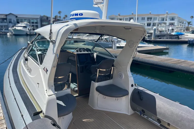 Slide: The Image of 2001 Protector Targa 28 boat docked at marina, showcasing interior seating and controls. - 3
