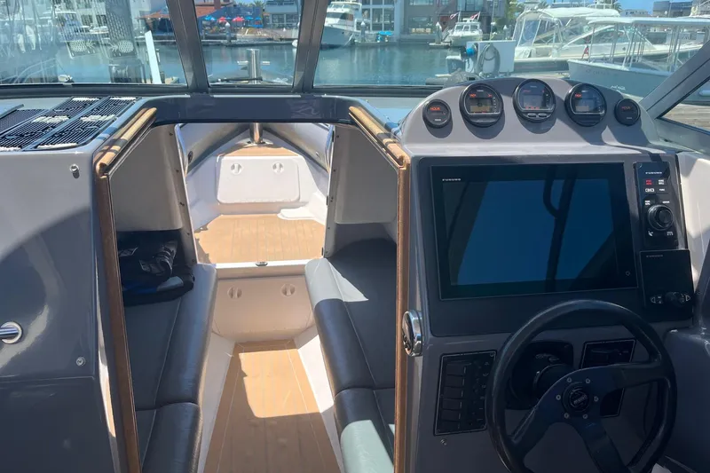 Slide: The Image of Interior view of a 2001 Protector Targa 28 boat with modern dashboard and seating. - 5