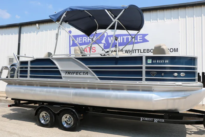 Slide: The Image of 2017 Trifecta 21 F Sts pontoon boat with blue canopy on trailer. - 1