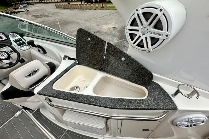 Slide: The Image of 2011 Chaparral 267 SSX boat interior with sink, speaker, and steering wheel. - 13