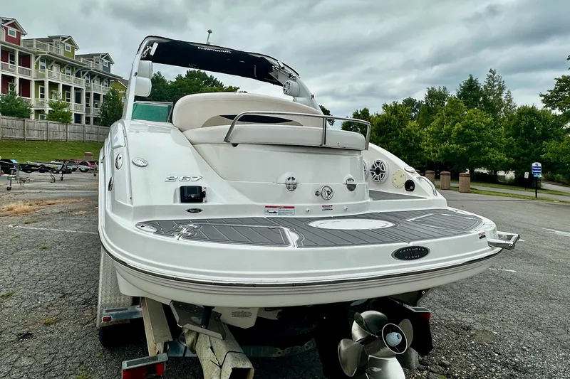Slide: The Image of 2011 Chaparral 267 SSX boat on trailer, parked outdoors near residential buildings. - 2