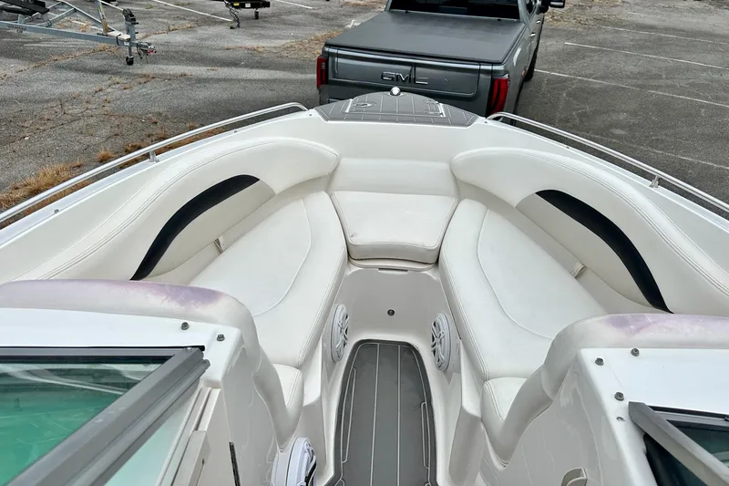 Slide: The Image of 2011 Chaparral 267 SSX boat interior with white seating and a GMC truck in background. - 7