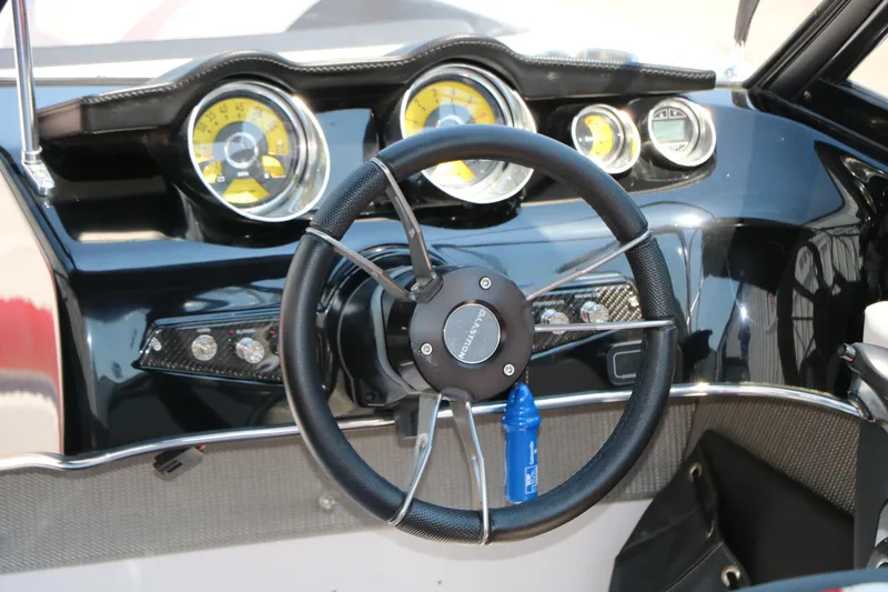 Slide: The Image of Steering wheel and dashboard of 2015 Glastron 205 GTS boat, featuring modern gauges. - 18