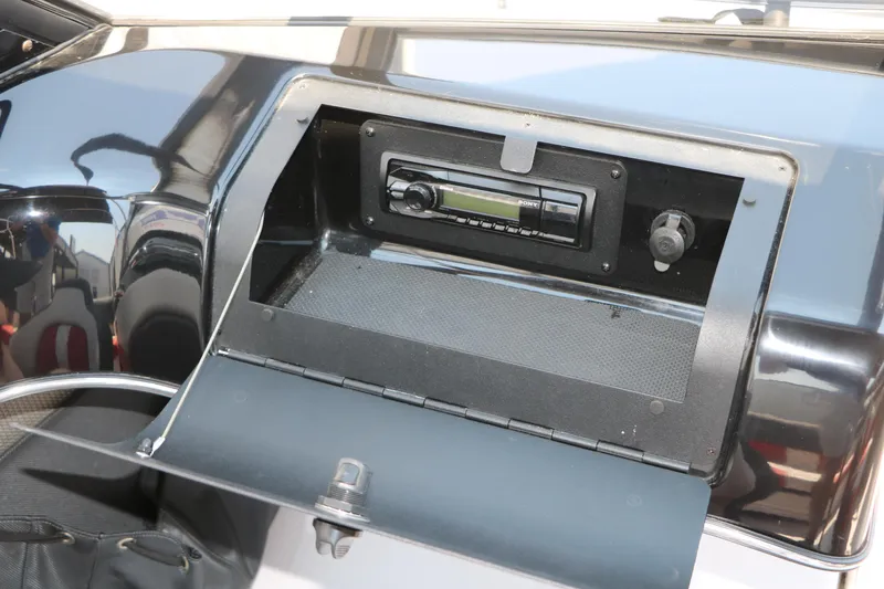 Slide: The Image of 2015 Glastron 205 GTS boat dashboard with stereo system and storage compartment. - 24