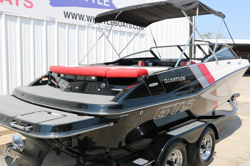Slide: The Image of 2015 Glastron 205 GTS boat with red and black accents, parked on a trailer. - 3