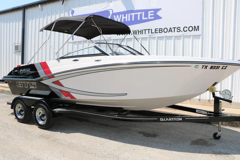 Slide: The Image of 2015 Glastron 205 GTS boat on trailer, displayed outside Whittle Boats dealership. - 5