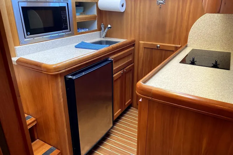 Slide: The Image of 2005 Mainship 34 Trawler kitchen with microwave, sink, and compact fridge. - 10