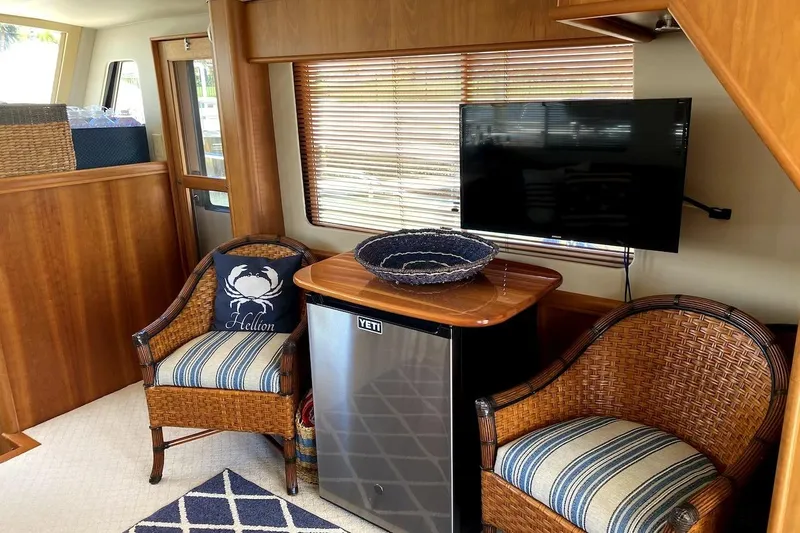 Slide: The Image of Interior of 2005 Mainship 34 Trawler with wicker chairs, TV, and mini fridge. - 16