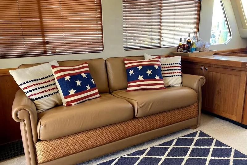 Slide: The Image of Luxurious 2005 Mainship 34 Trawler interior with patriotic-themed cushions on a leather sofa. - 18