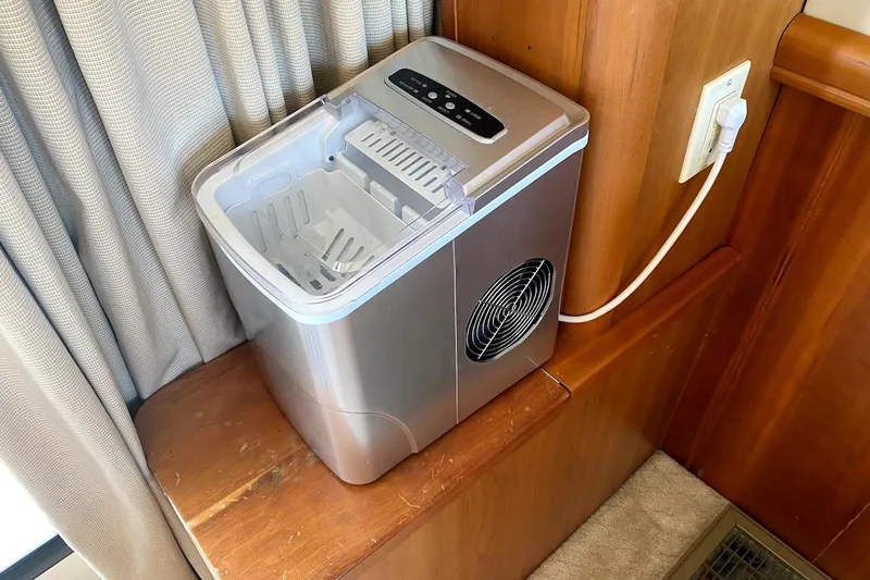 Slide: The Image of Portable ice maker on a wooden shelf inside a 2005 Mainship 34 Trawler. - 23