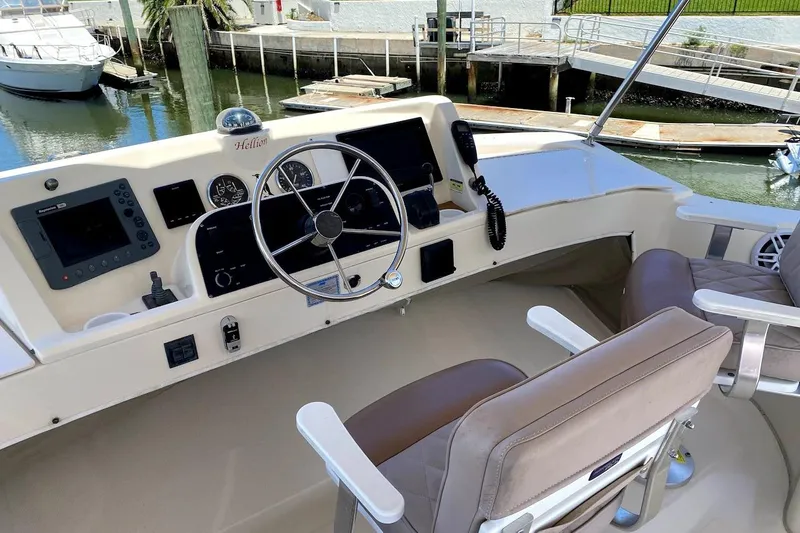 Slide: The Image of 2005 Mainship 34 Trawler helm with steering wheel, navigation equipment, and comfortable seating. - 26