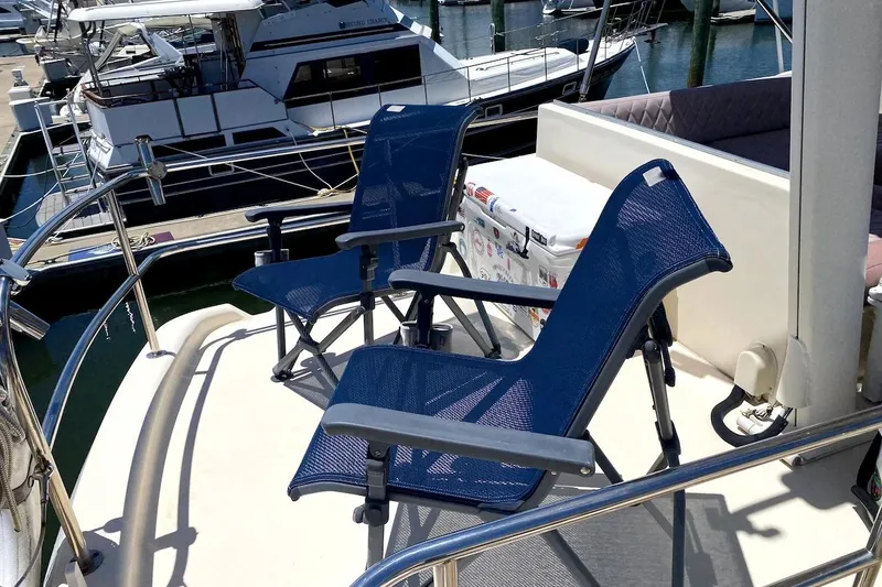 Slide: The Image of Deck of 2005 Mainship 34 Trawler with blue chairs and cooler. - 36