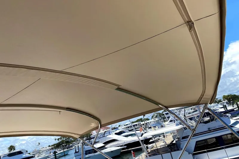 Slide: The Image of Bimini top of 2005 Mainship 34 Trawler at marina, showcasing boat canopy design. - 37