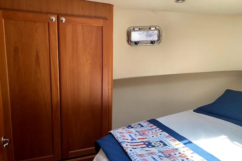Slide: The Image of 2005 Mainship 34 Trawler cabin interior with wooden closet and bed. - 4