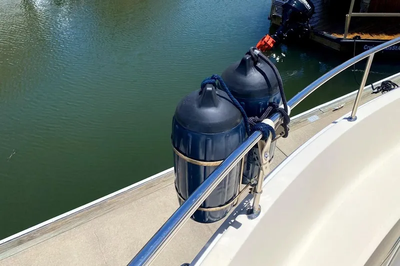 Slide: The Image of 2005 Mainship 34 Trawler with fenders docked by calm water. - 41