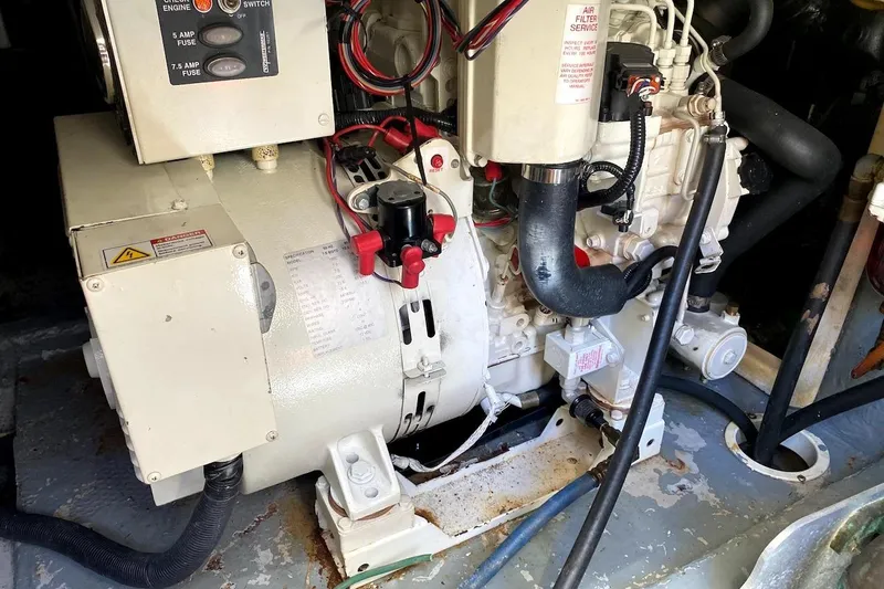 Slide: The Image of Engine room of a 2005 Mainship 34 Trawler, showcasing mechanical components and wiring. - 50