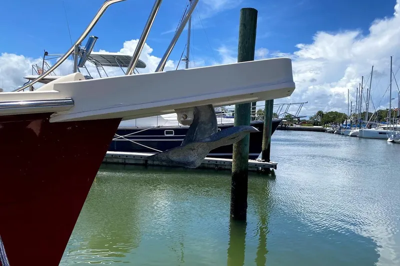 Slide: The Image of 2005 Mainship 34 Trawler anchored in a marina under a clear blue sky. - 57