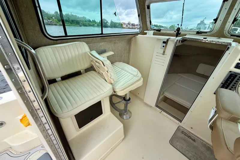 Slide: The Image of Interior of a 2008 Parker 2520XLD boat with seating and cabin view. - 12