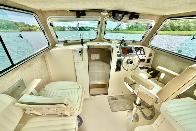 Slide: The Image of Interior of a 2008 Parker 2520XLD boat with steering wheel and seating. - 13