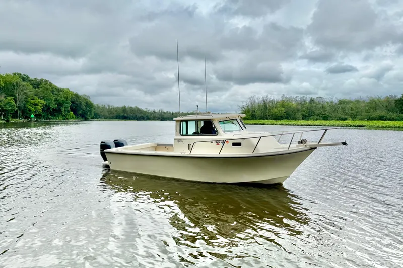 Slide: The Image of 2008 Parker 2520XLD boat on a calm river under cloudy skies. - 2