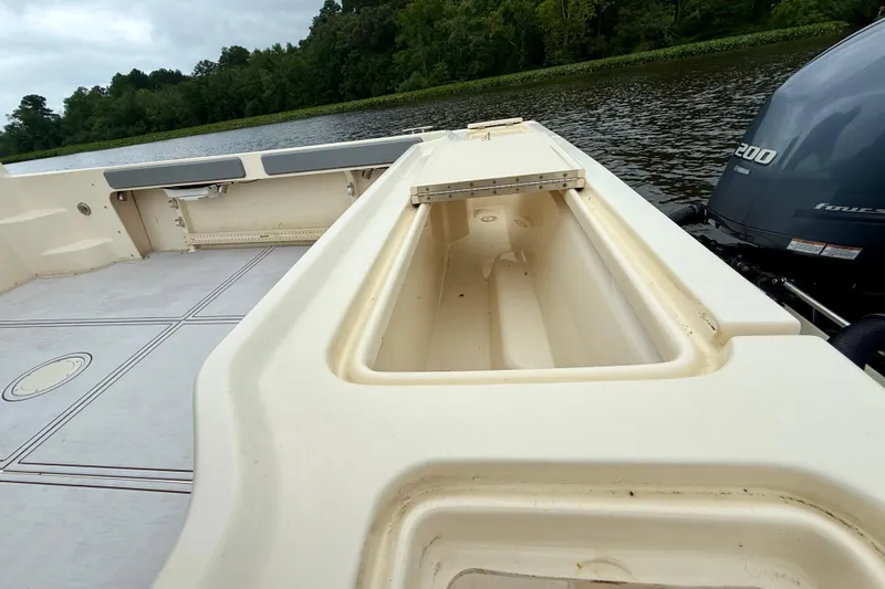 Slide: The Image of 2008 Parker 2520XLD boat interior with open storage, Yamaha engine, and scenic water backdrop. - 5