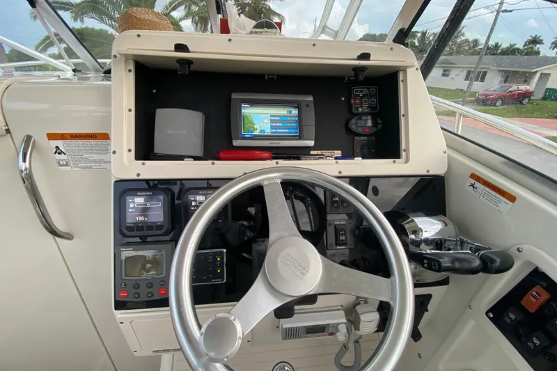 Slide: The Image of 2004 Hydra-Sports Vector 2800 WA boat dashboard with steering wheel and navigation controls. - 15