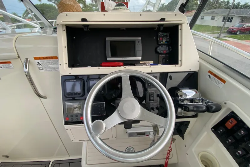 Slide: The Image of 2004 Hydra-Sports Vector 2800 WA boat dashboard with steering wheel and control panel. - 17
