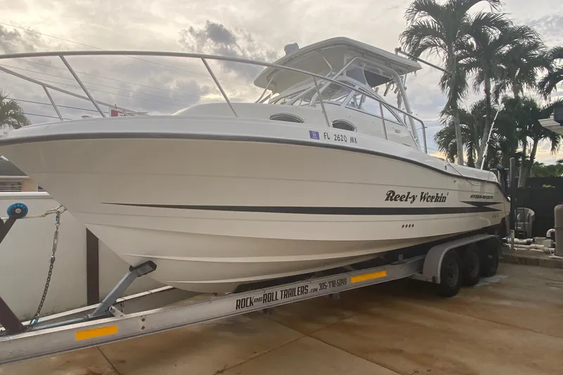 Slide: The Image of 2004 Hydra-Sports Vector 2800 WA boat on trailer, parked near palm trees. - 2