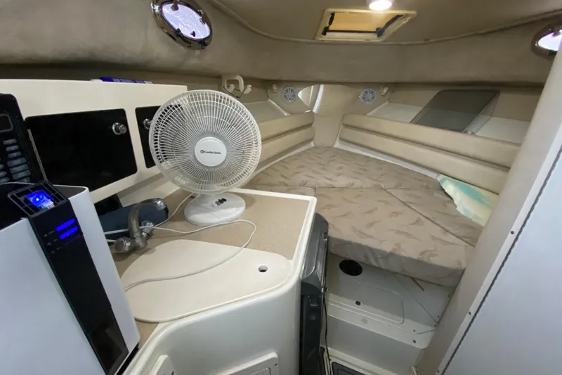 Slide: The Image of 2004 Hydra-Sports Vector 2800 WA cabin interior with bed, fan, and compact amenities. - 22