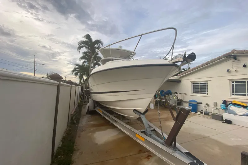 Slide: The Image of 2004 Hydra-Sports Vector 2800 WA boat on trailer beside house, under cloudy sky. - 5