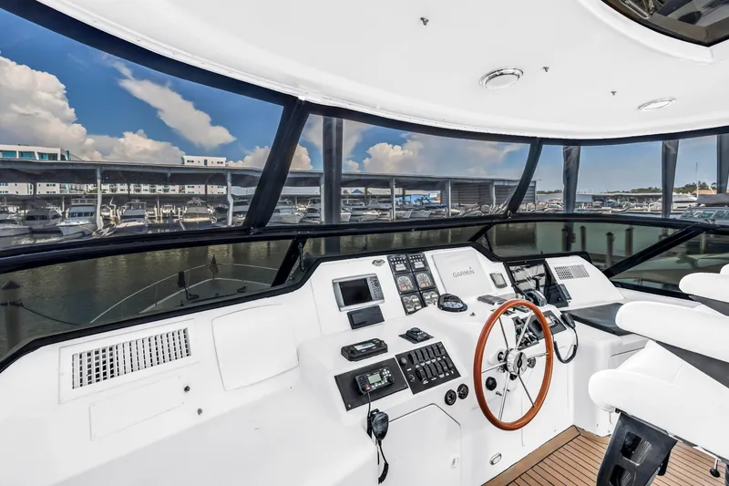 Slide: The Image of Flybridge helm of 2000 Neptunus 65 yacht with modern navigation equipment and marina view. - 11