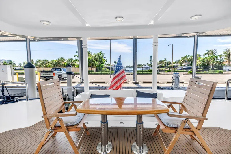 Slide: The Image of Outdoor seating on 2000 Neptunus 65 Flybridge yacht with wooden chairs and table. - 15