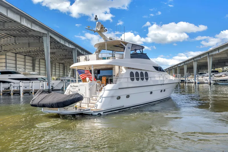 Slide: The Image of Luxury Neptunus 65 Flybridge yacht, 2000 model, docked under a clear blue sky. - 2