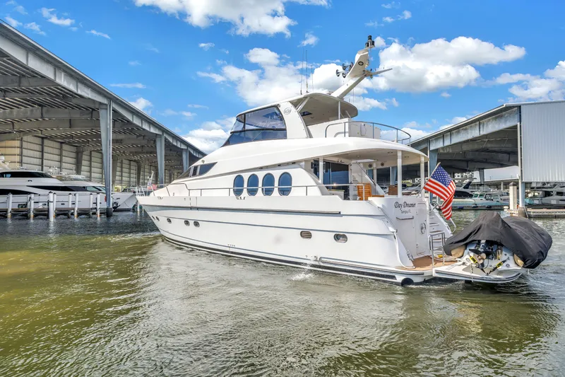 Slide: The Image of Luxury Neptunus 65 Flybridge yacht docked, 2000 model, with American flag, under blue sky. - 3