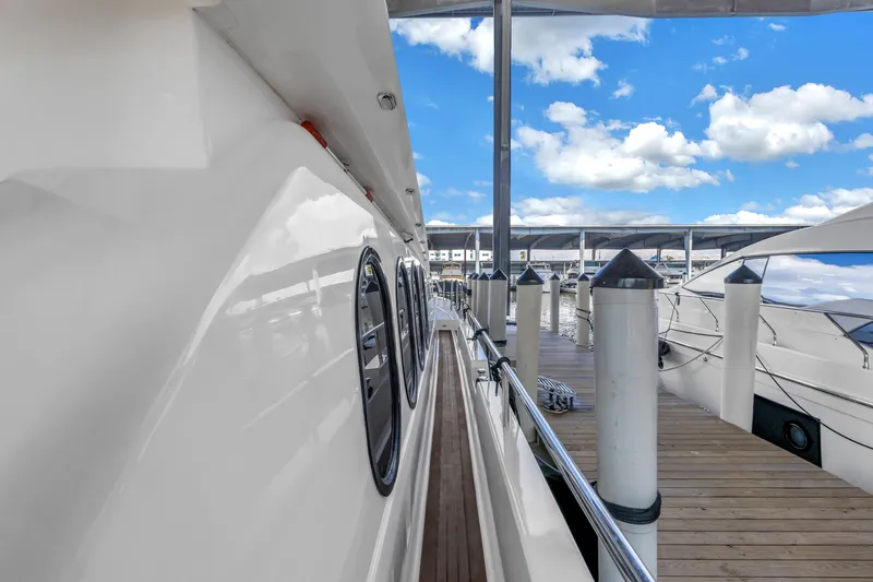 Slide: The Image of Side view of 2000 Neptunus 65 Flybridge yacht docked at marina under blue sky. - 50