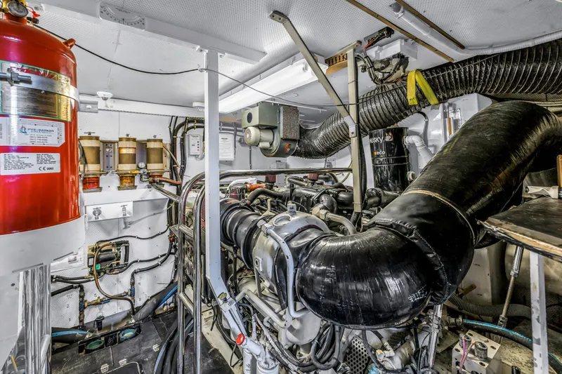 Slide: The Image of Engine room of 2000 Neptunus 65 Flybridge yacht, featuring complex machinery and equipment. - 58