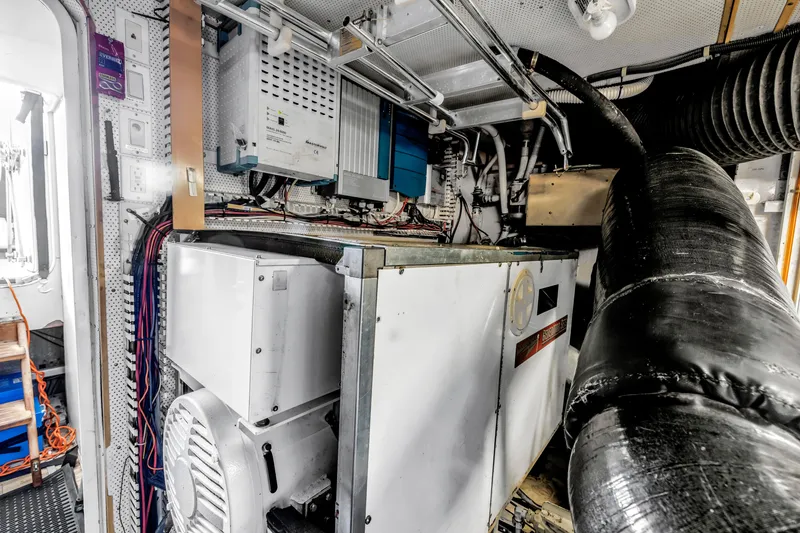 Slide: The Image of Engine room of 2000 Neptunus 65 Flybridge yacht, showcasing machinery and wiring. - 60