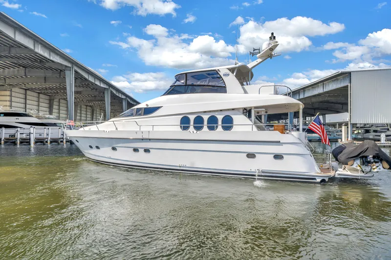 Slide: The Image of 2000 Neptunus 65 Flybridge yacht docked in marina under blue sky. - 8