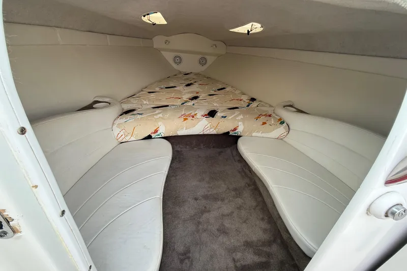 Slide: The Image of 1994 Baja Boss 272 boat interior with cushioned seating and patterned bedding. - 17