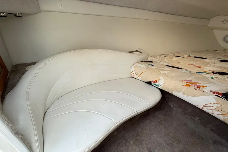 Slide: The Image of Interior of a 1994 Baja Boss 272 boat with white seating and patterned bedding. - 19