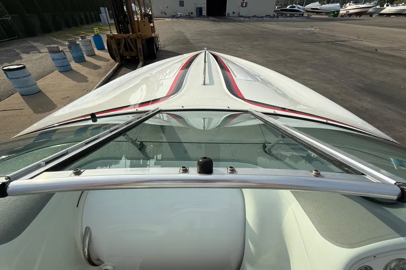 Slide: The Image of 1994 Baja Boss 272 boat with sleek design and red accents, docked outdoors. - 21