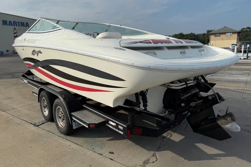 Slide: The Image of 1994 Baja Boss 272 speedboat on trailer at marina, featuring sleek design and vibrant graphics. - 4