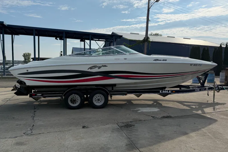 Slide: The Image of 1994 Baja Boss 272 boat on trailer, white with red and black accents, parked outdoors. - 5