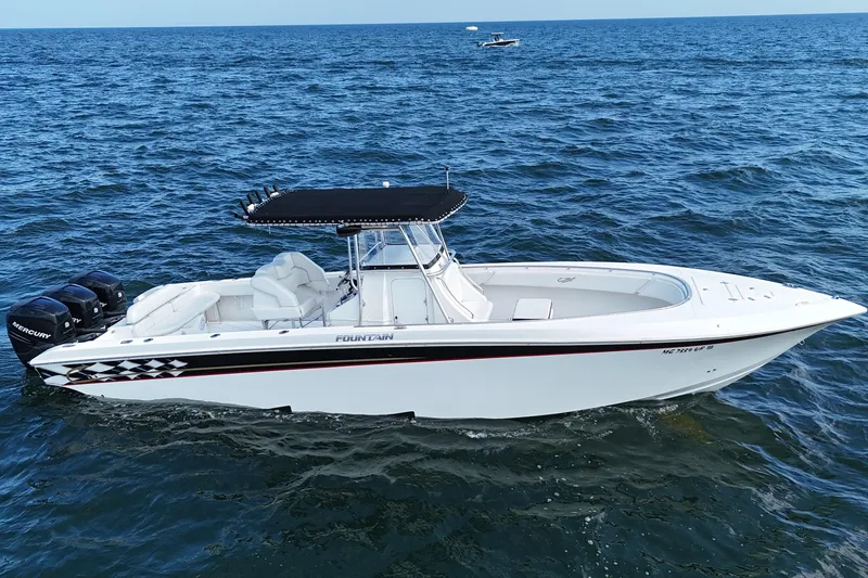 Slide: The Image of 2005 Fountain 34 Sportfish CC Open Bow on ocean, featuring triple Mercury engines. - 1