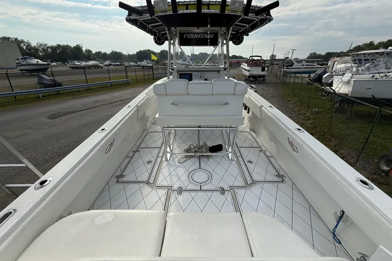 Slide: The Image of 2005 Fountain 34 Sportfish CC Open Bow boat, spacious deck, marina background. - 12