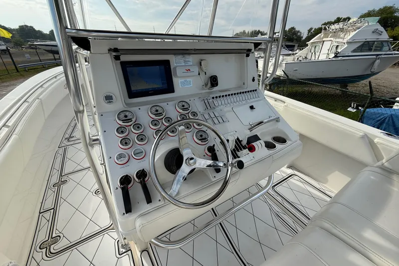 Slide: The Image of 2005 Fountain 34 Sportfish CC Open Bow boat dashboard with steering wheel and controls. - 13